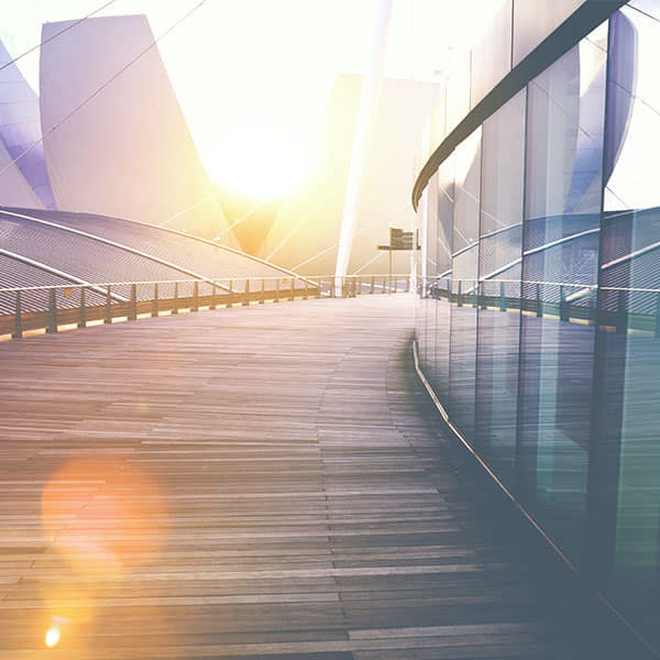 Sunrise over modern architecture symbolizing how delivering something great leads to a bright future